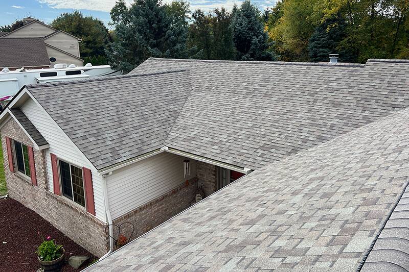 Aerial of a ranch home with a completed shingle roof