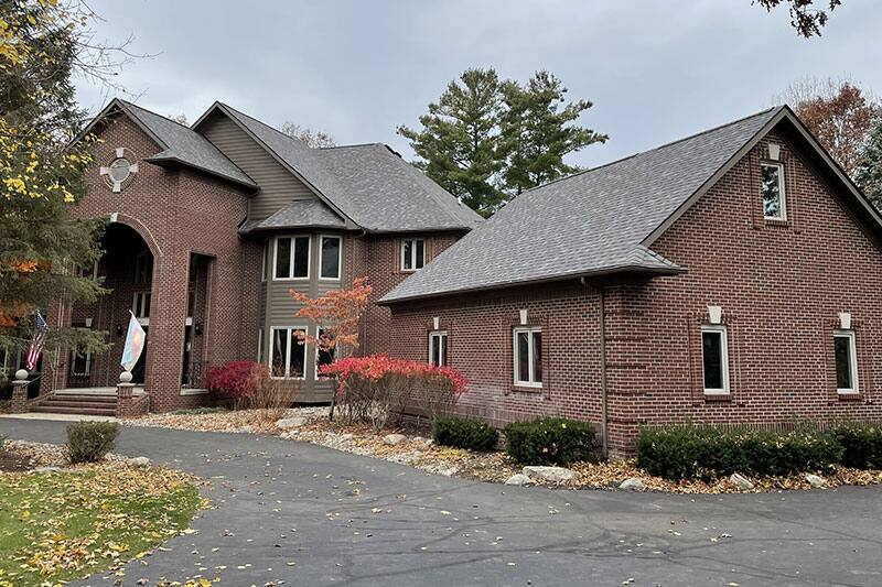 Tudor-style brick home with a completed shingle replacement