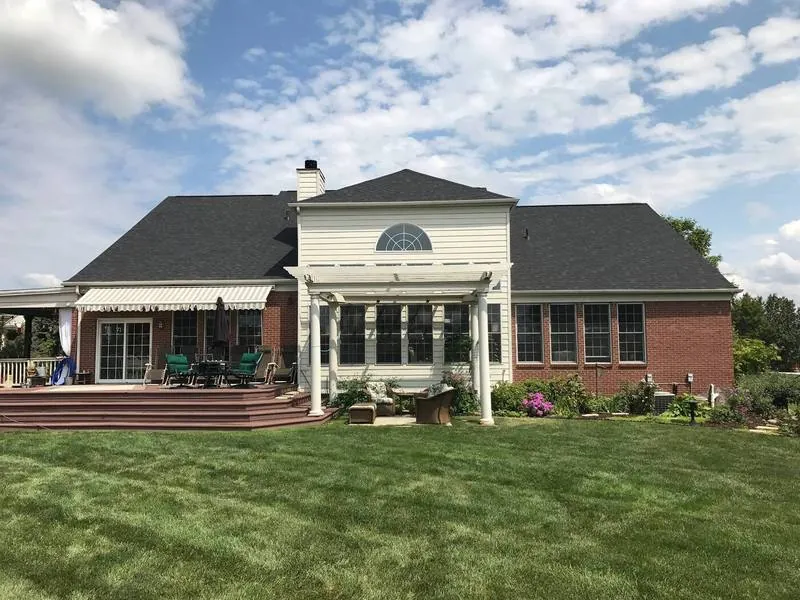 New roof on a brick and siding home with a covered deck and pergola