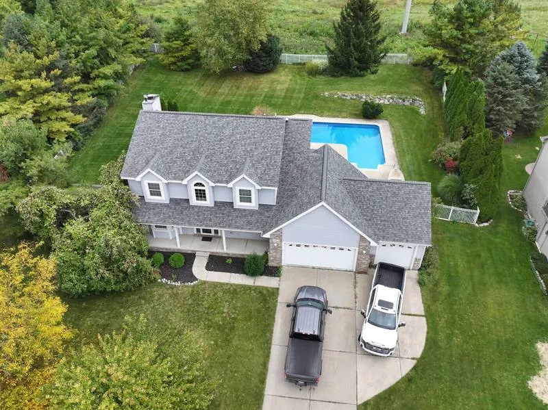 Drone view of a completed roof on a home with a pool