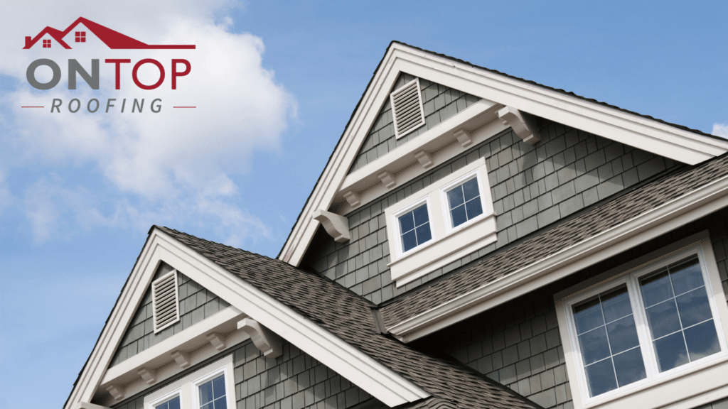 Close-up view of a green house with white trim featuring gabled roofs and the logo of "on top roofing" at the top left.