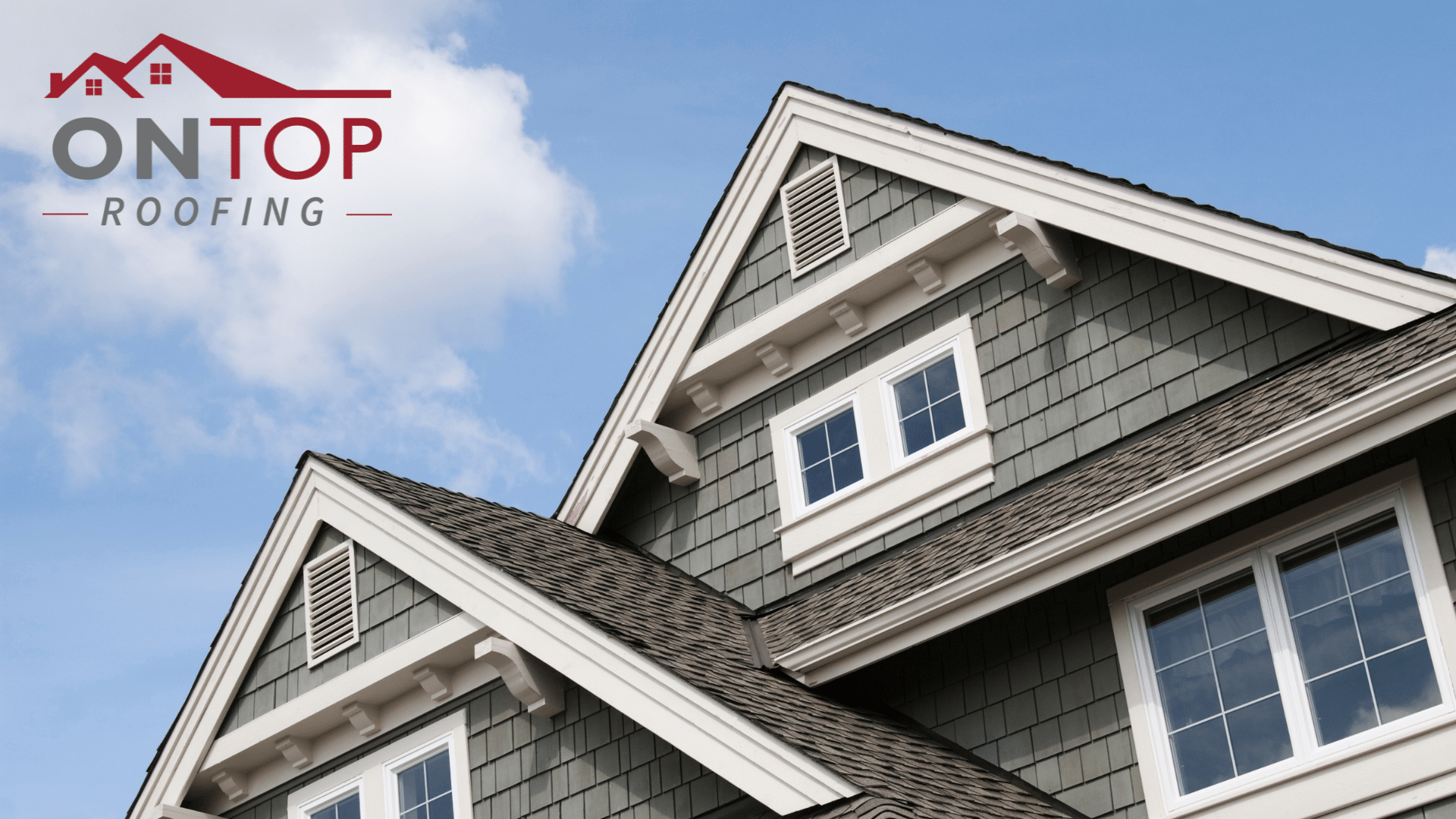 Close-up view of a green house with white trim featuring gabled roofs and the logo of "on top roofing" at the top left.