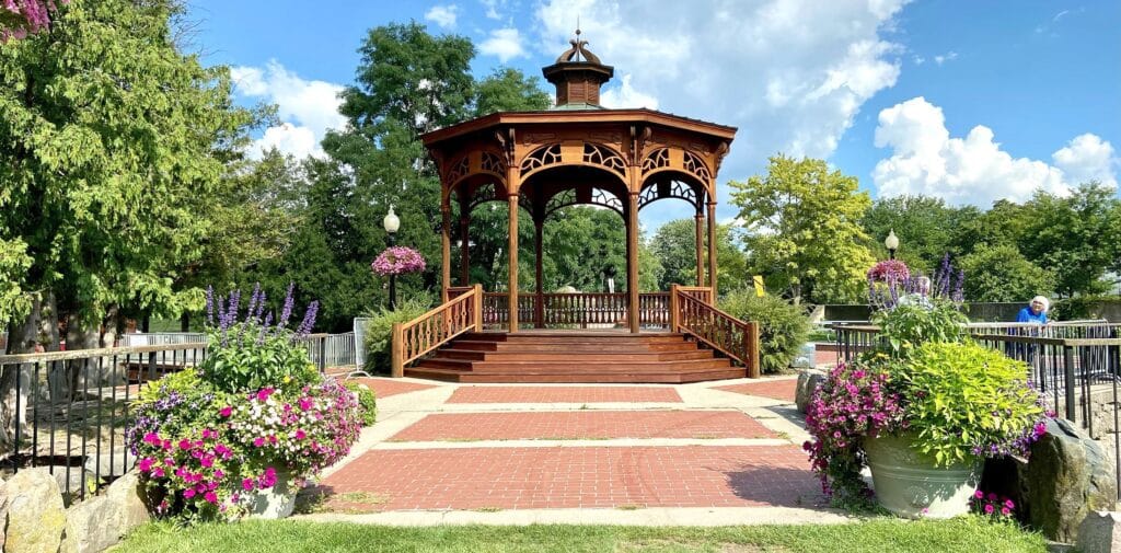 a wooden gazebo surrounded by flowers