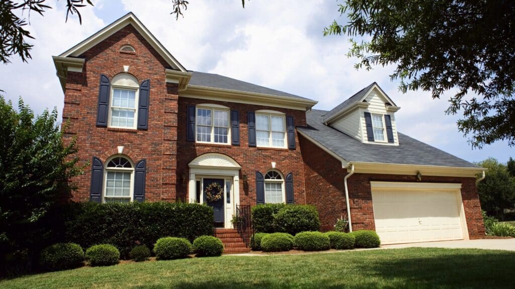 Two-story red brick suburban house with white trim