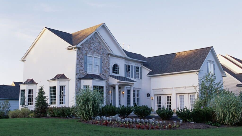 Two-story suburban house with stone and white siding exterior