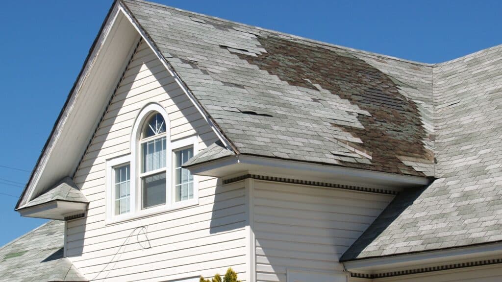 The roof of a house with missing shingles